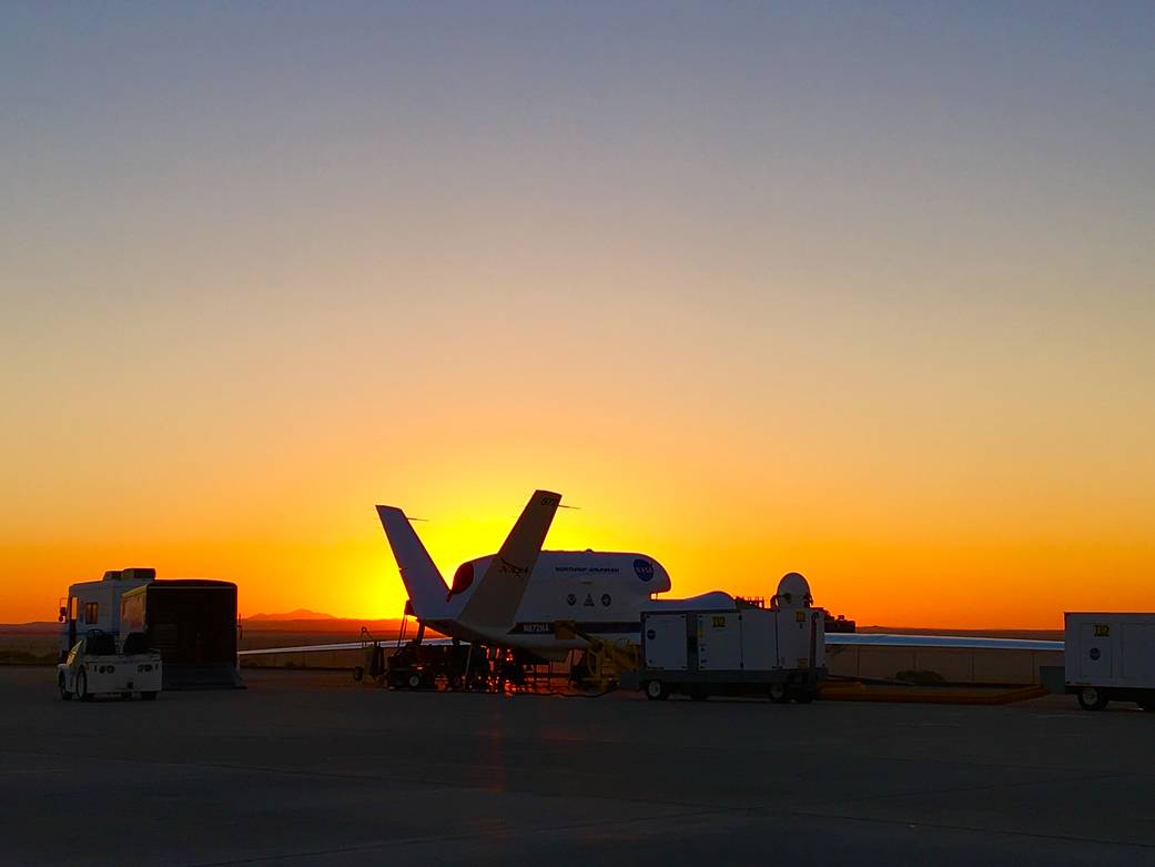 A NASA Global Hawk unmanned aircraft being prepared before sunrise